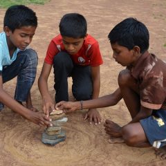 Boys pile rocks for game outside
